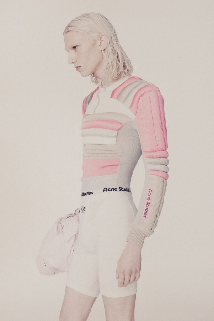 A fitted pink and gray striped long-sleeve top paired with white shorts.
