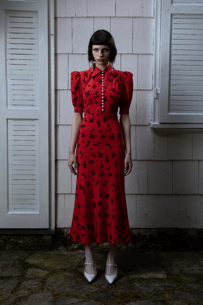 A fitted red silk dress with short sleeves, a collared neckline, and a flared silhouette.