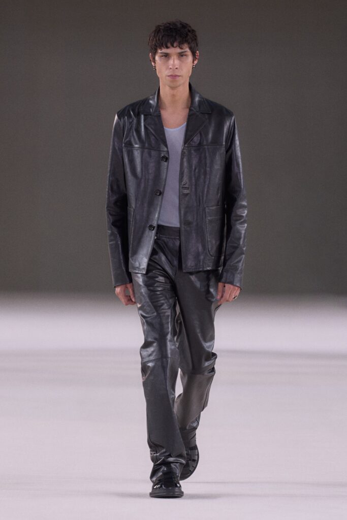 A fitted black leather jacket with a collared neckline paired with straight-leg pants.
