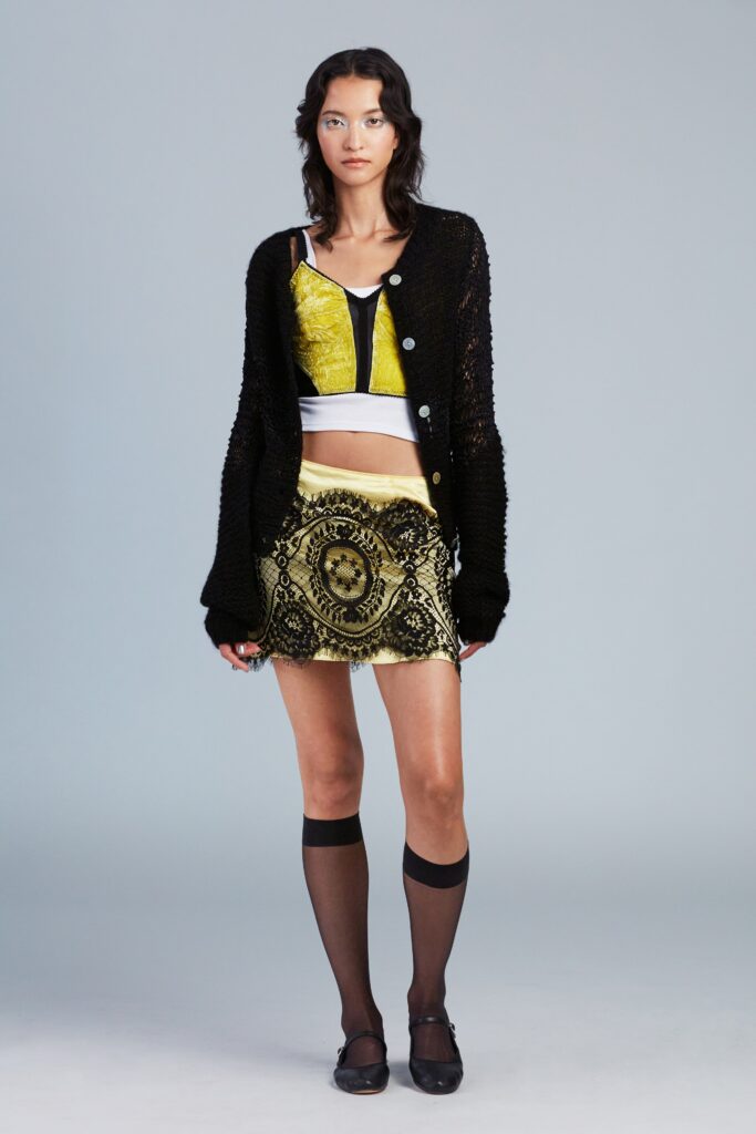 black cardigan white crop-top gold skirt