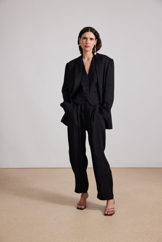 A relaxed black cotton suit featuring a collared long-sleeve jacket and wide-leg trousers.