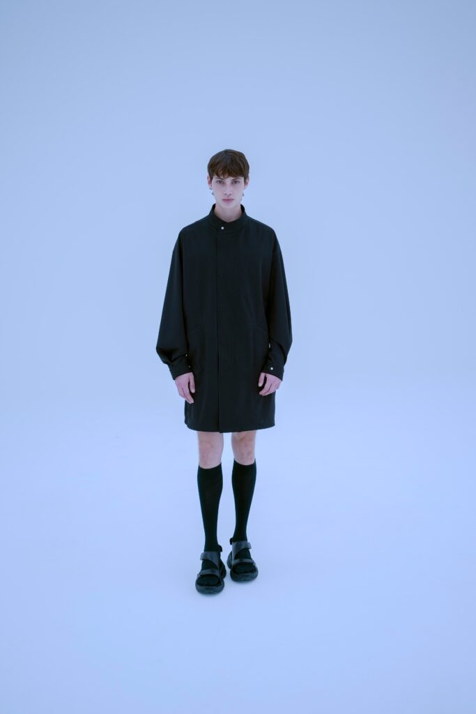 An oversized black coat with long sleeves and a collared design.