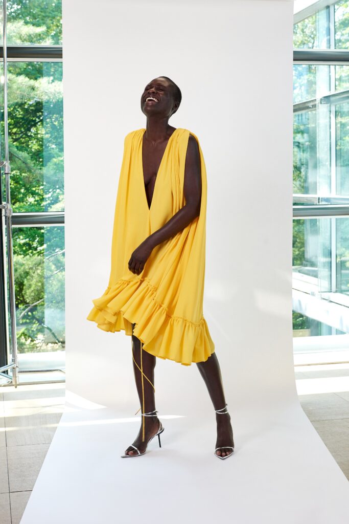 A relaxed yellow silk sleeveless dress with a V-neckline and tiered design.