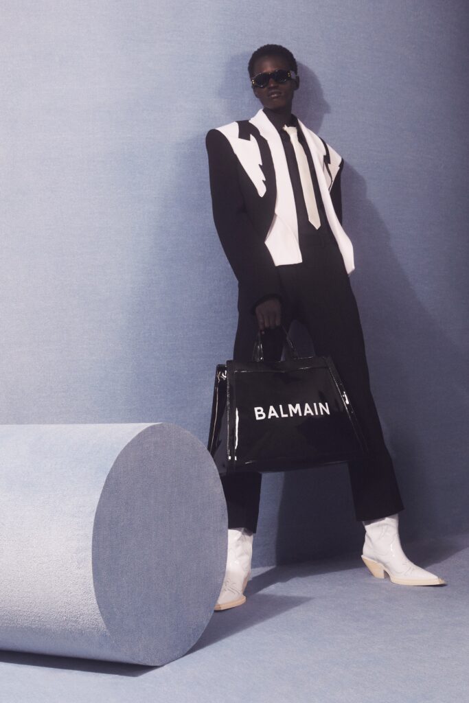 A tailored black and white suit with long sleeves and a striking design, paired with stylish accessories.