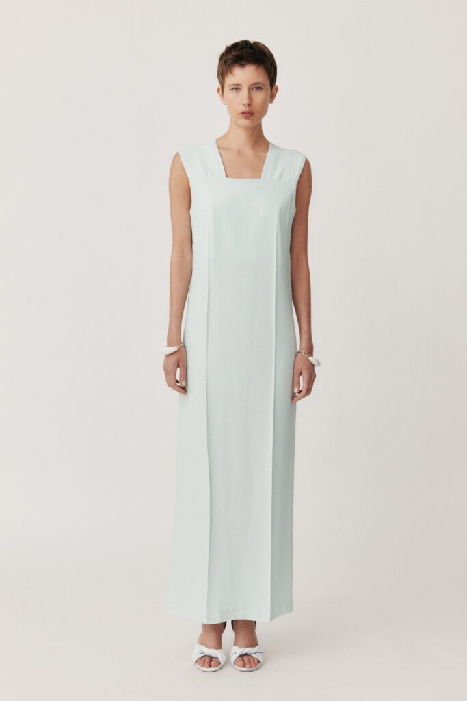 A fitted blue silk maxi dress with a sleeveless design and square neckline.