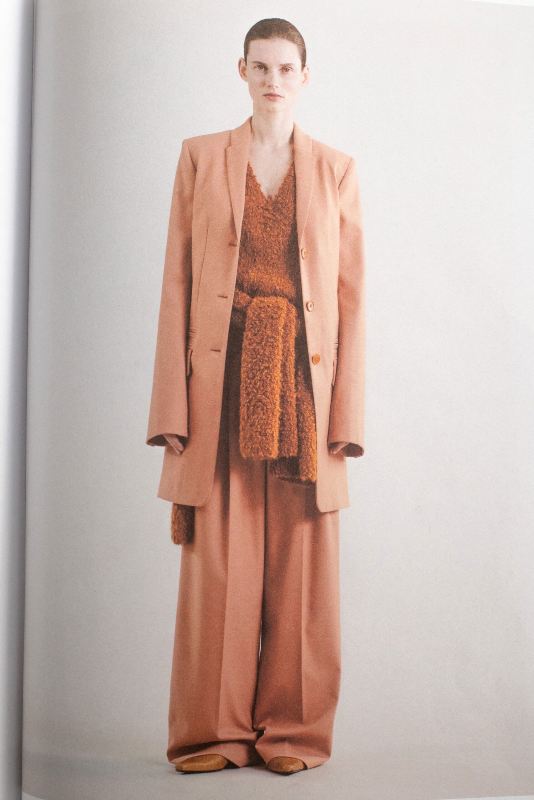 A relaxed beige wool blazer paired with wide-leg pants and a V-neck top.