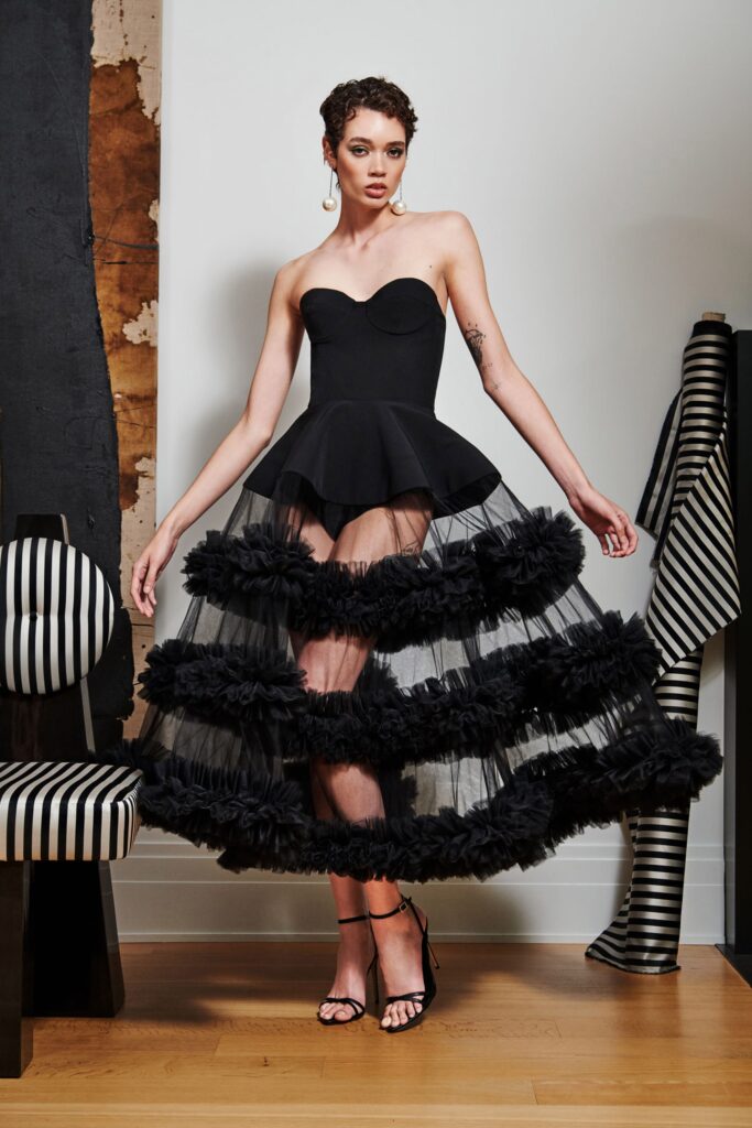 A fitted black strapless dress featuring a tiered design with ruffled details.