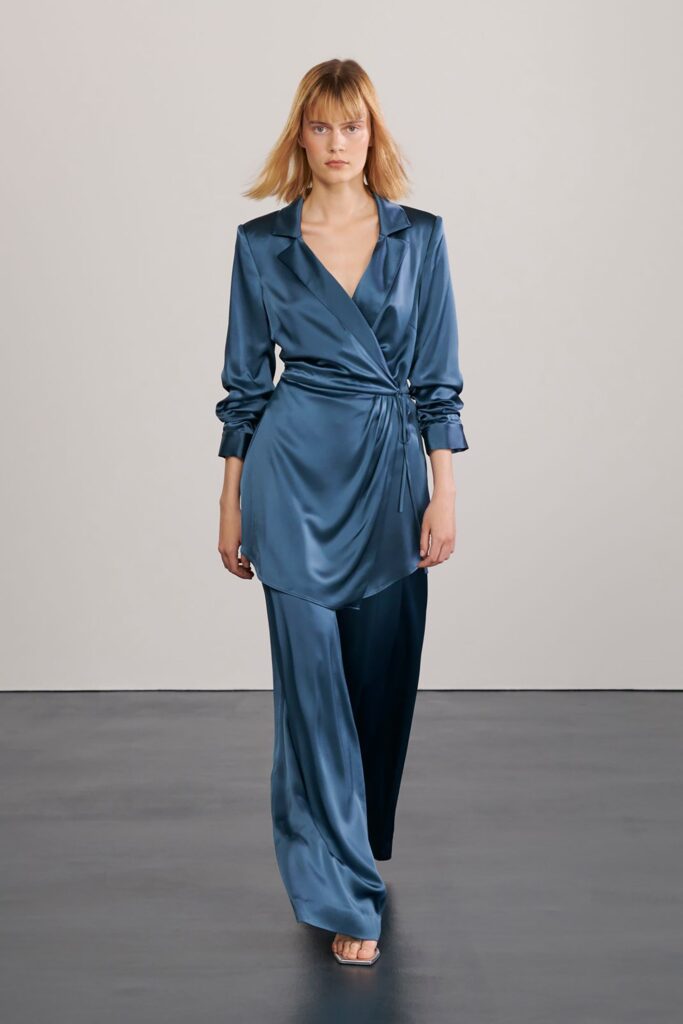 A relaxed blue silk long-sleeve blouse with a collared design paired with matching pants.
