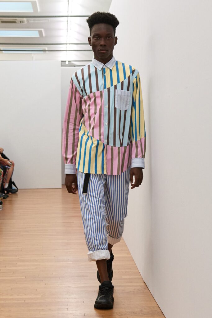 A relaxed fit long-sleeve collared shirt paired with striped pants in pastel colors.
