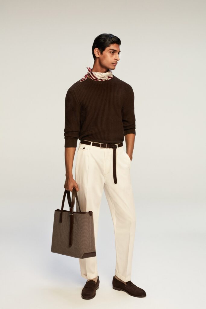 A fitted brown long-sleeve sweater paired with straight-leg white pants.