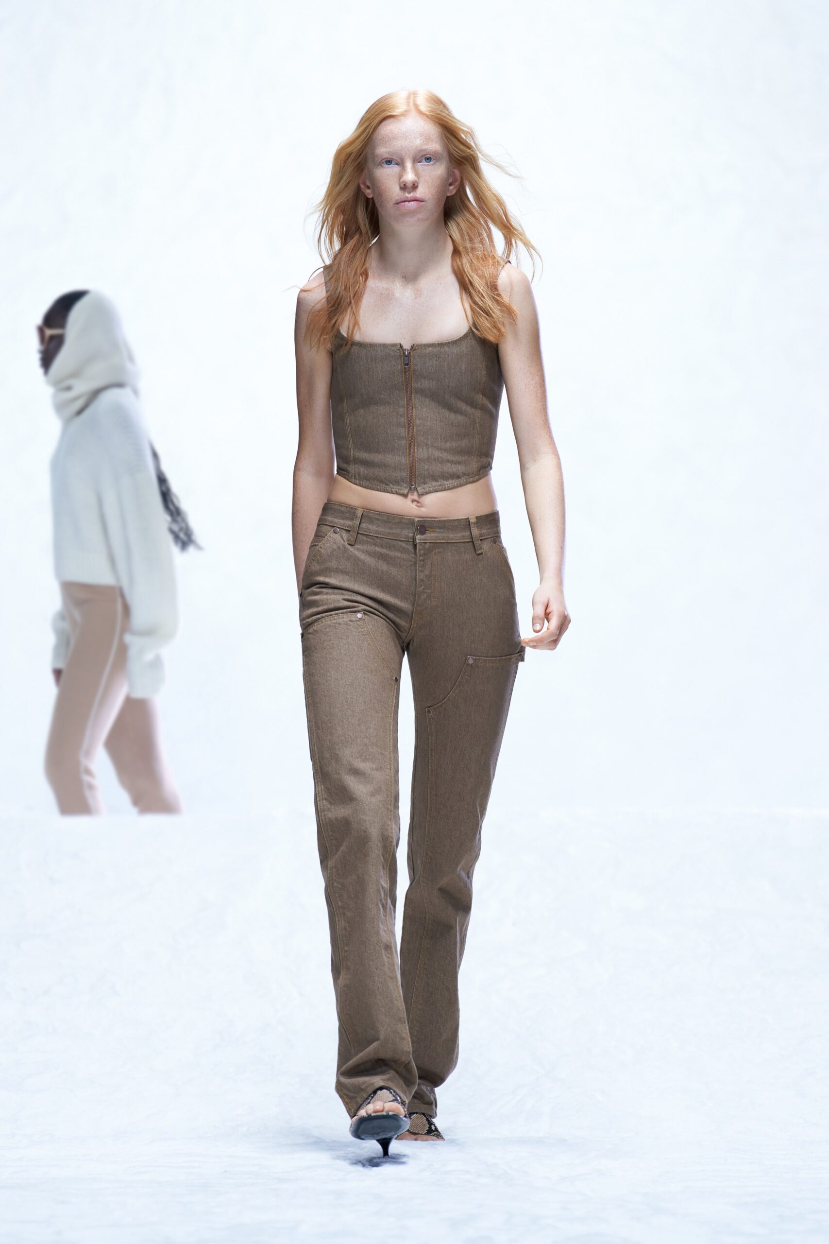 A fitted brown denim sleeveless top with zippered detail paired with straight-leg pants.