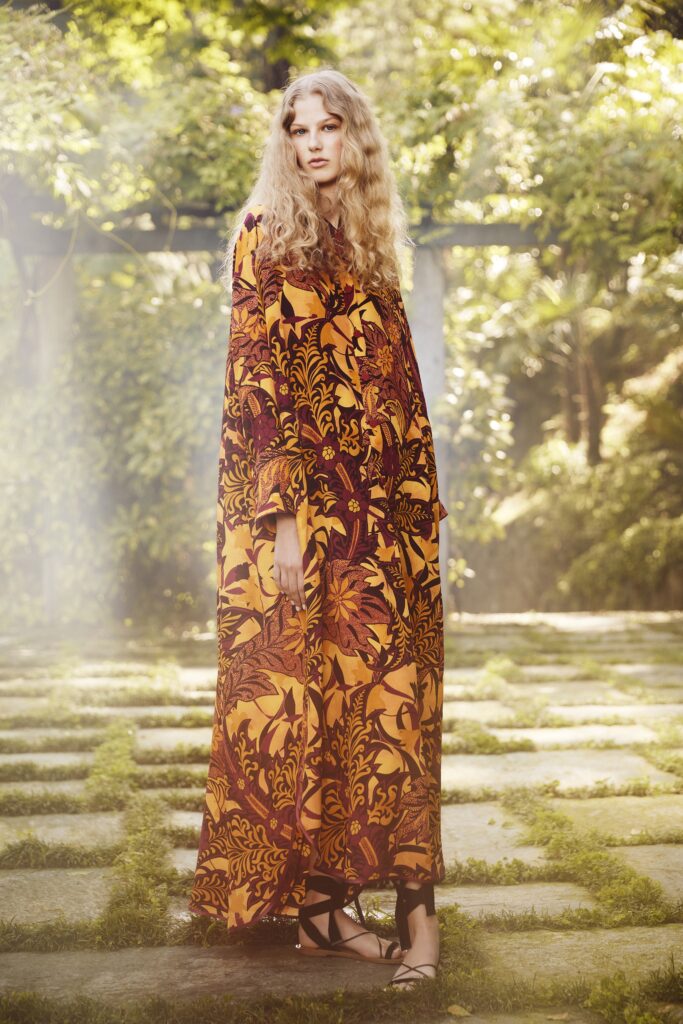 A relaxed long-sleeve dress in orange and brown with a collared neckline and printed design.