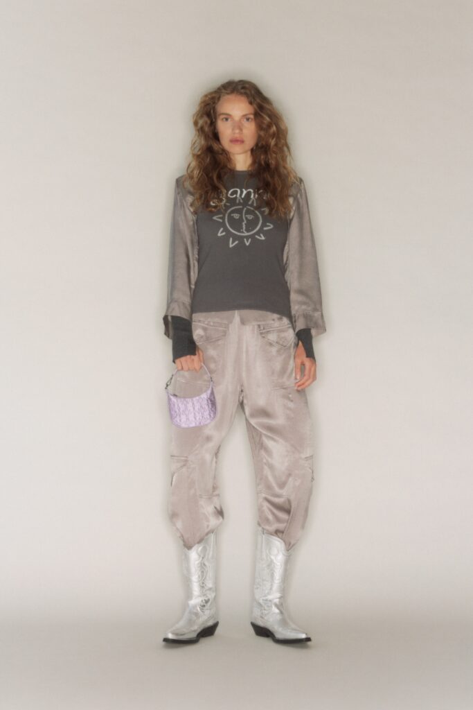 A relaxed gray printed long-sleeve top paired with silver wide-leg pants.
