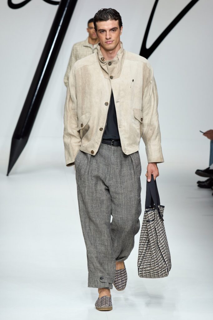 A relaxed beige cotton jacket paired with gray wide-leg pants, featuring a collared design.