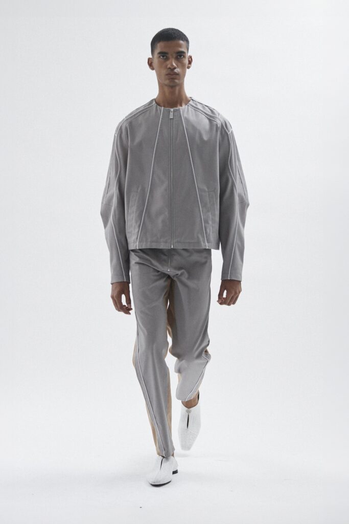 A relaxed gray jacket with long sleeves and zippered detail, paired with matching pants.