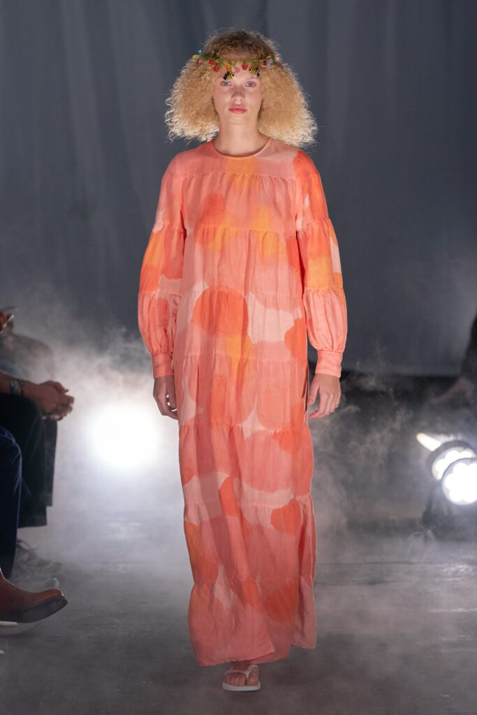 A relaxed orange cotton dress with long sleeves and a tiered design.