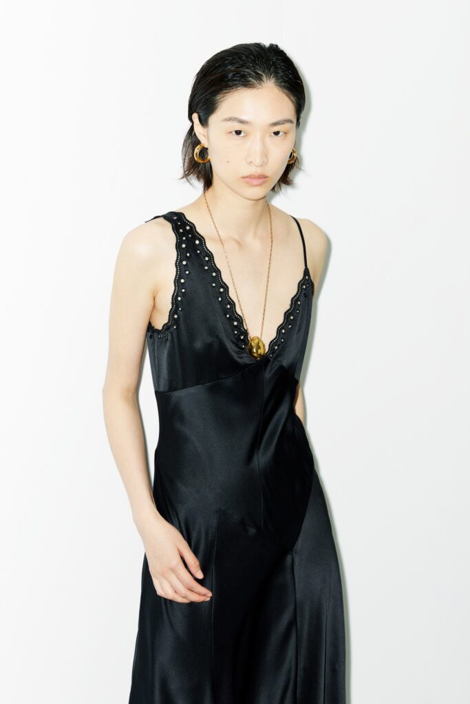 A fitted black silk dress with a sleeveless design and V-neckline.