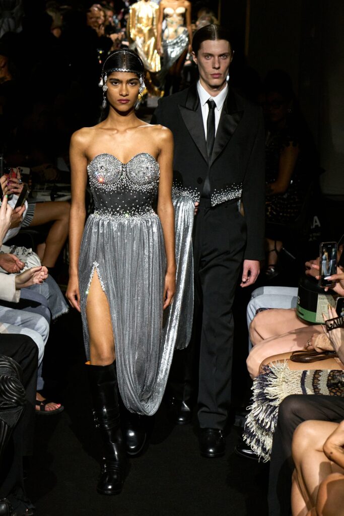 A fitted silver silk sleeveless dress with a V-neckline and a thigh-high slit.