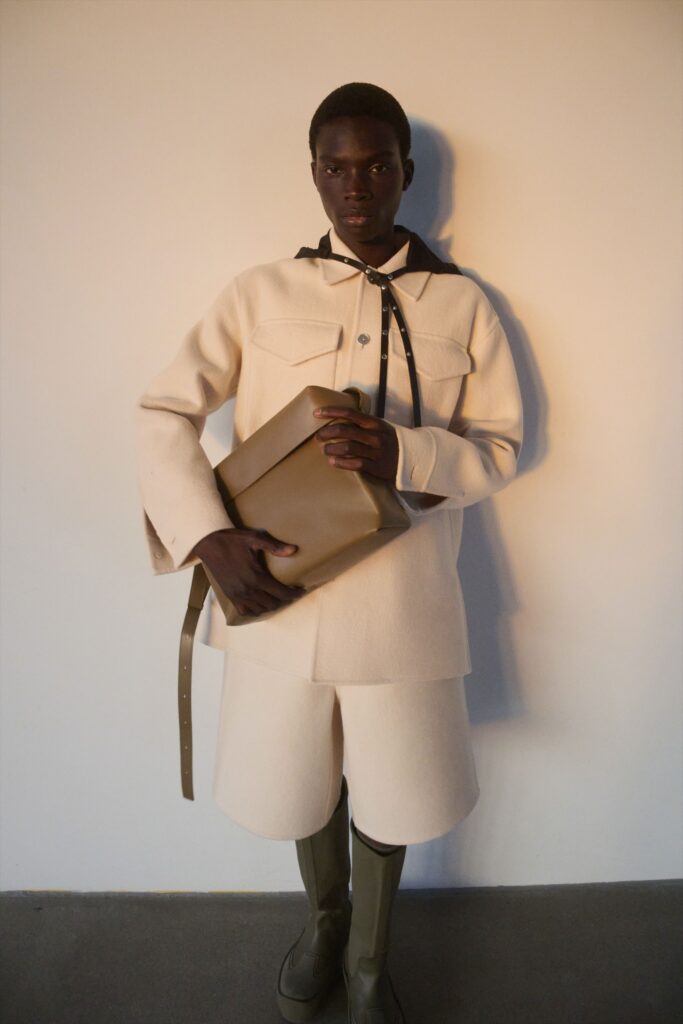 A relaxed beige wool jacket with long sleeves and a collared design, paired with matching shorts.