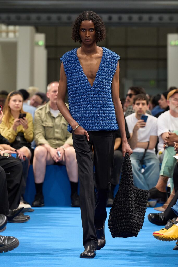 A fitted blue sleeveless top with a V-neckline paired with sleek black pants.