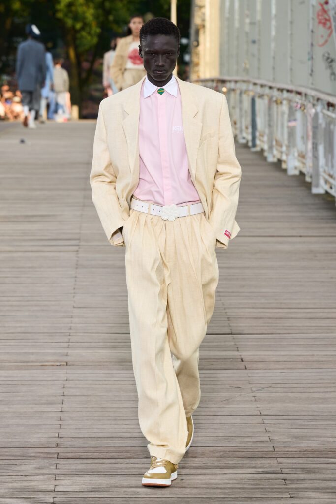 A relaxed beige cotton suit with a long-sleeve collared shirt and wide-leg trousers.