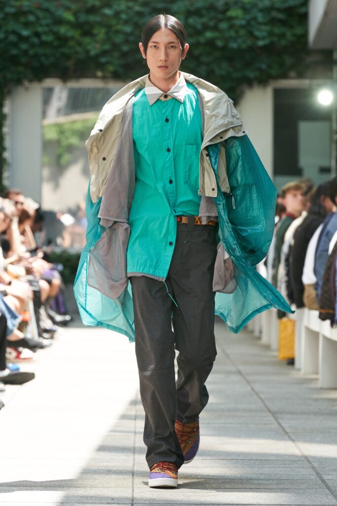 A relaxed blue jacket layered over a collared shirt, featuring long sleeves and a contemporary design.