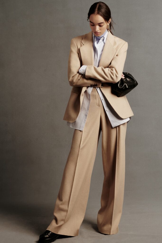 A relaxed beige wool blazer paired with wide-leg pants and a collared shirt.