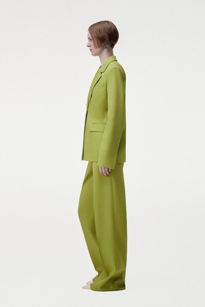 A relaxed fit green suit with long sleeves and a collared neckline, featuring wide-leg trousers.