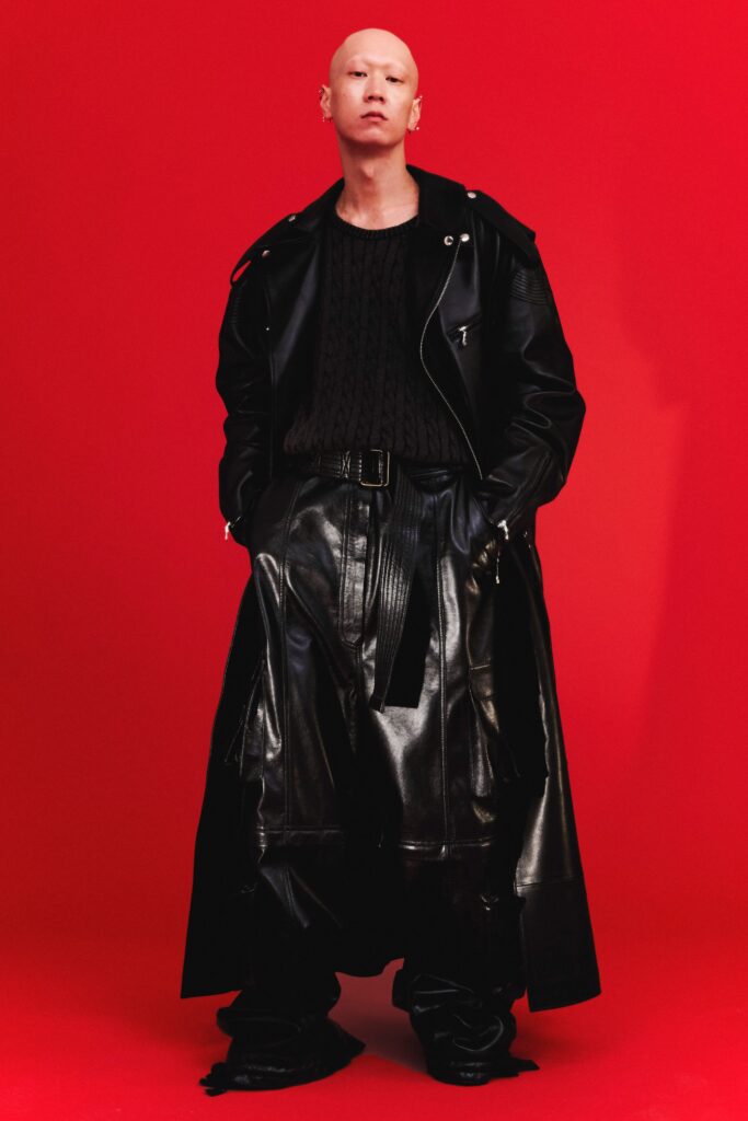 A fitted black leather coat with long sleeves and layered pants for a bold look.