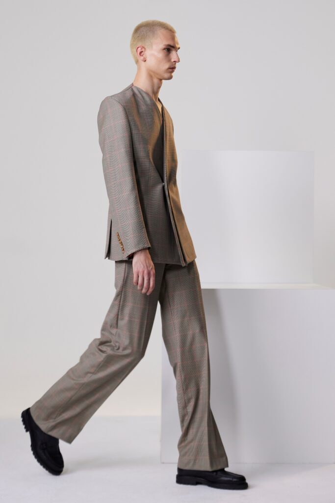 A tailored beige suit with a long-sleeve collared jacket and checked pattern.