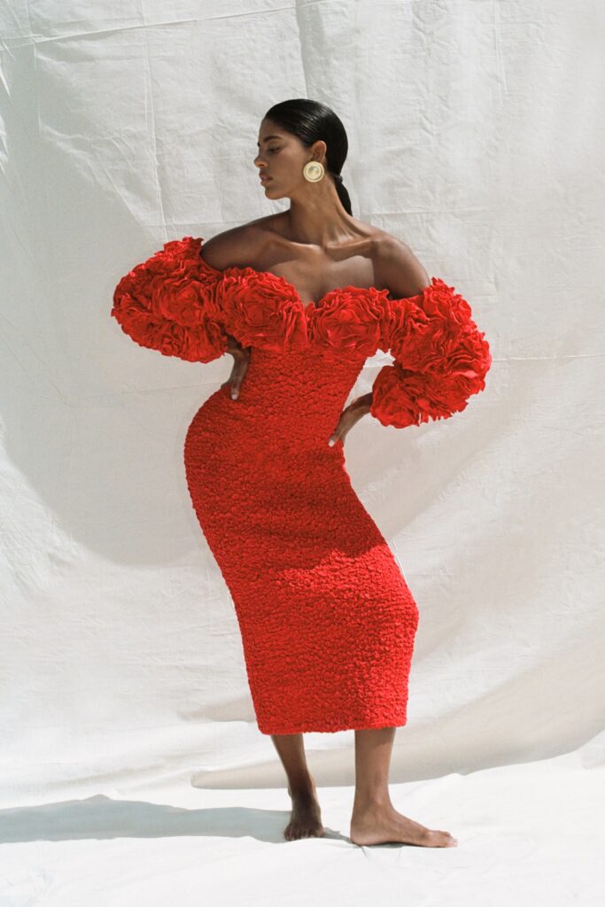 A fitted red dress with off-shoulder design and ruffled details for a striking look.