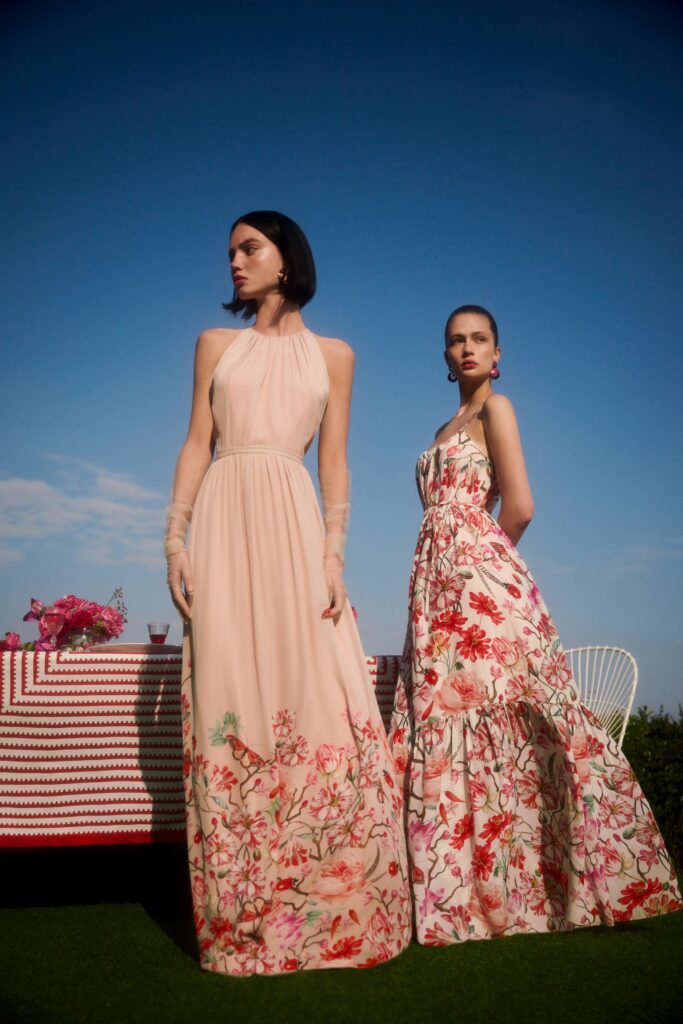 A fitted pink floral sleeveless dress with a V-neckline and tiered design.