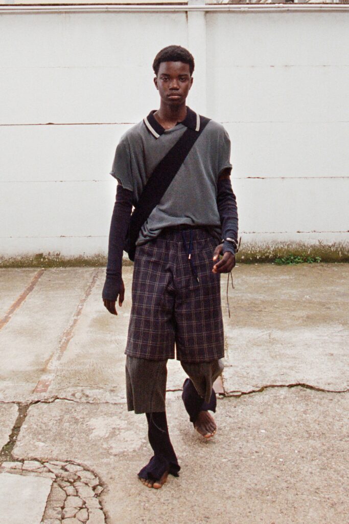 A relaxed gray top paired with checked shorts, creating a casual yet stylish look.