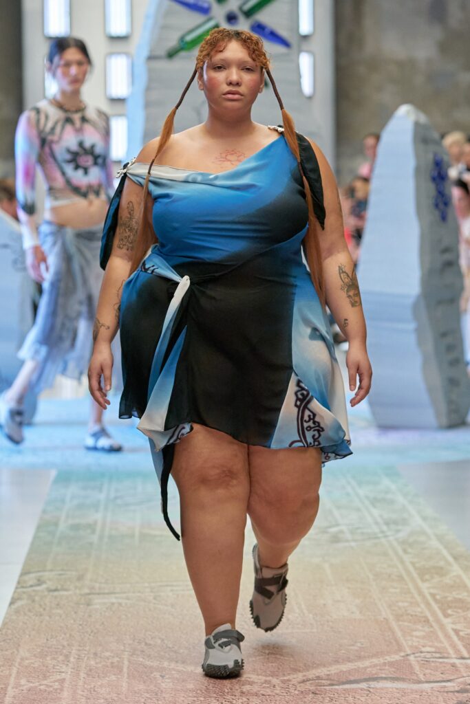 A relaxed blue silk off-shoulder dress with an asymmetric design.