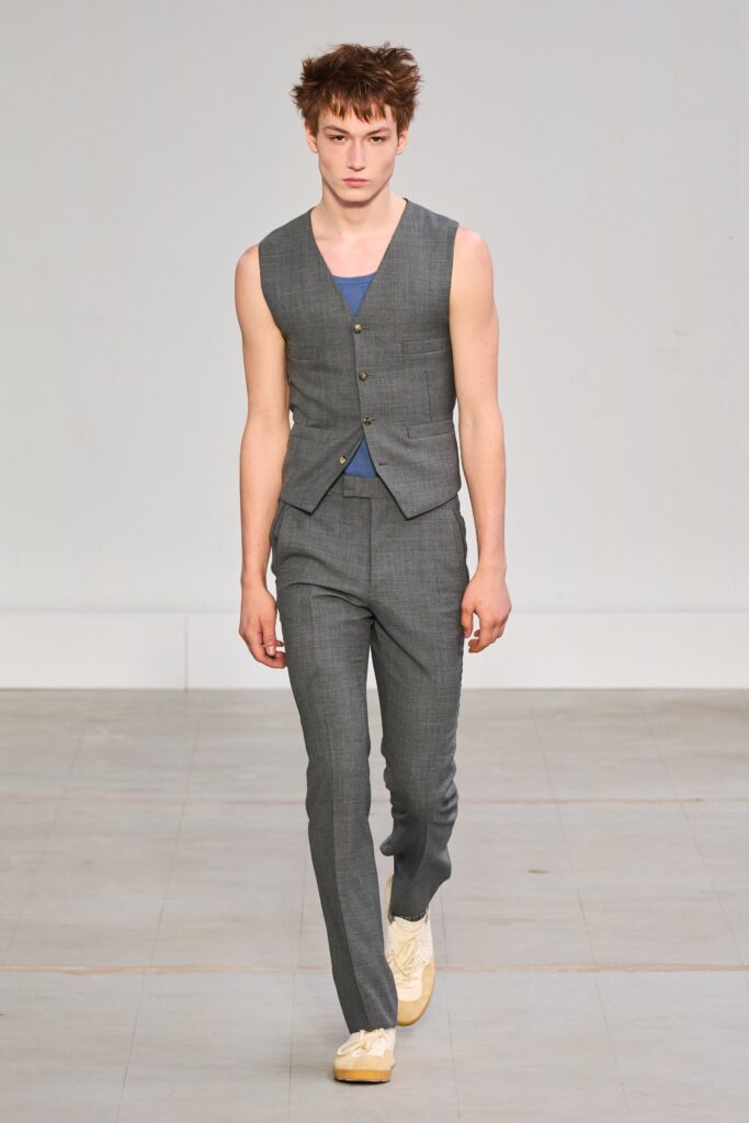 A fitted gray sleeveless vest paired with straight-leg pants, featuring a buttoned design.