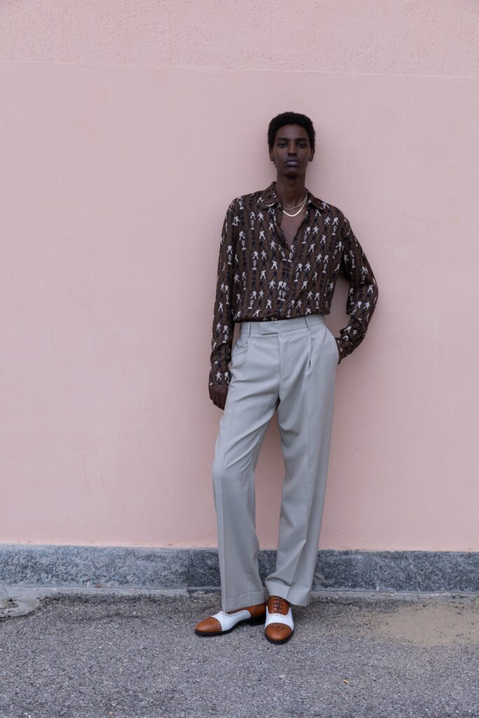 A relaxed brown printed long-sleeve shirt paired with wide-leg beige trousers.