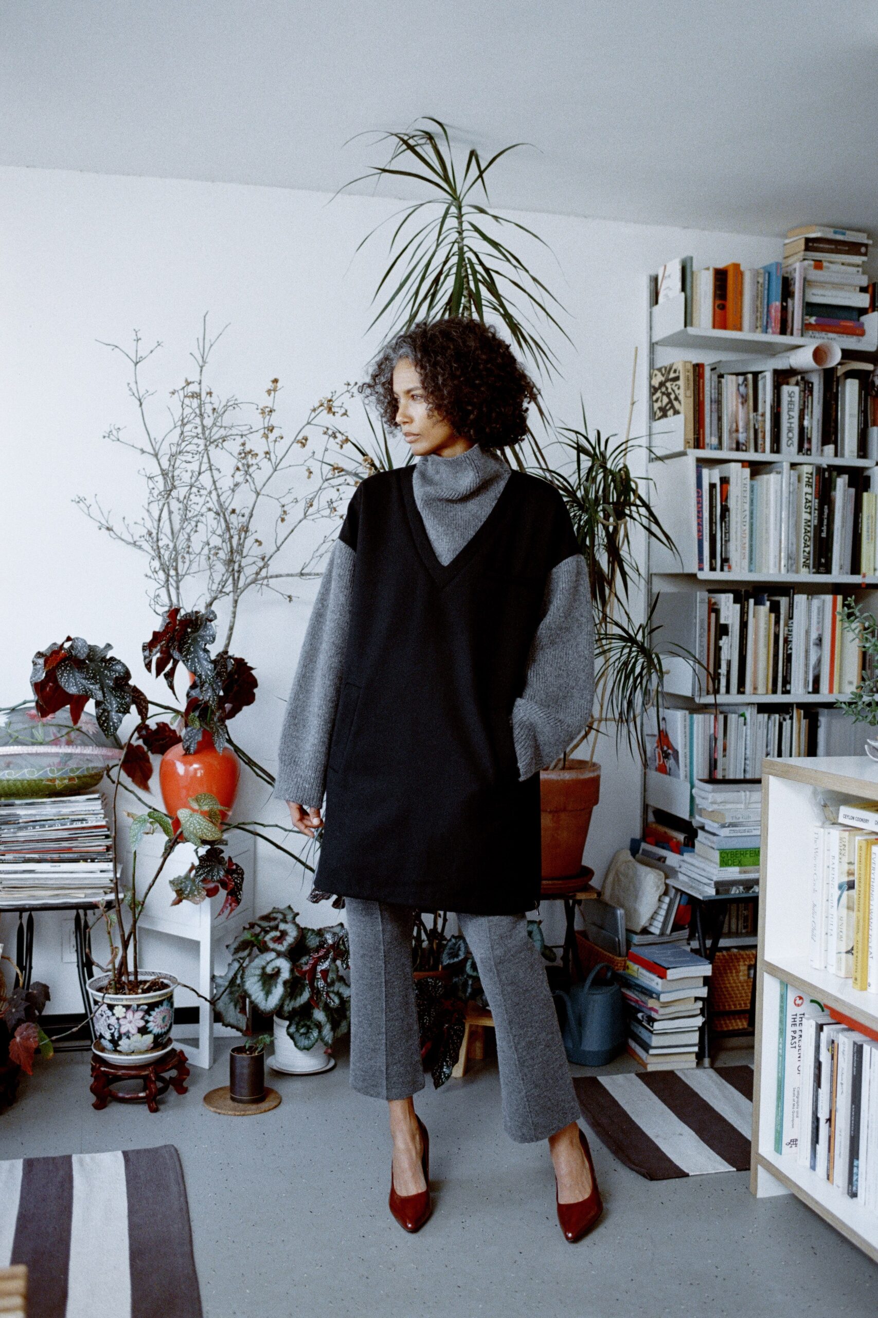 A relaxed black dress layered over a gray long-sleeve top with a V-neckline and asymmetric design.