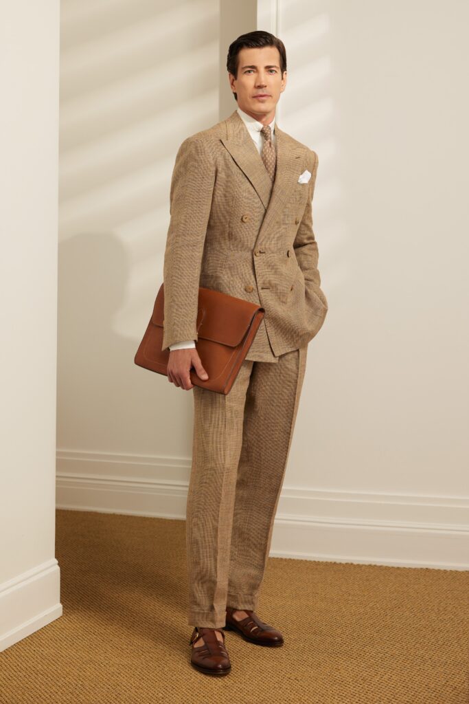 A tailored beige suit with long sleeves, a collared shirt, and buttoned details.