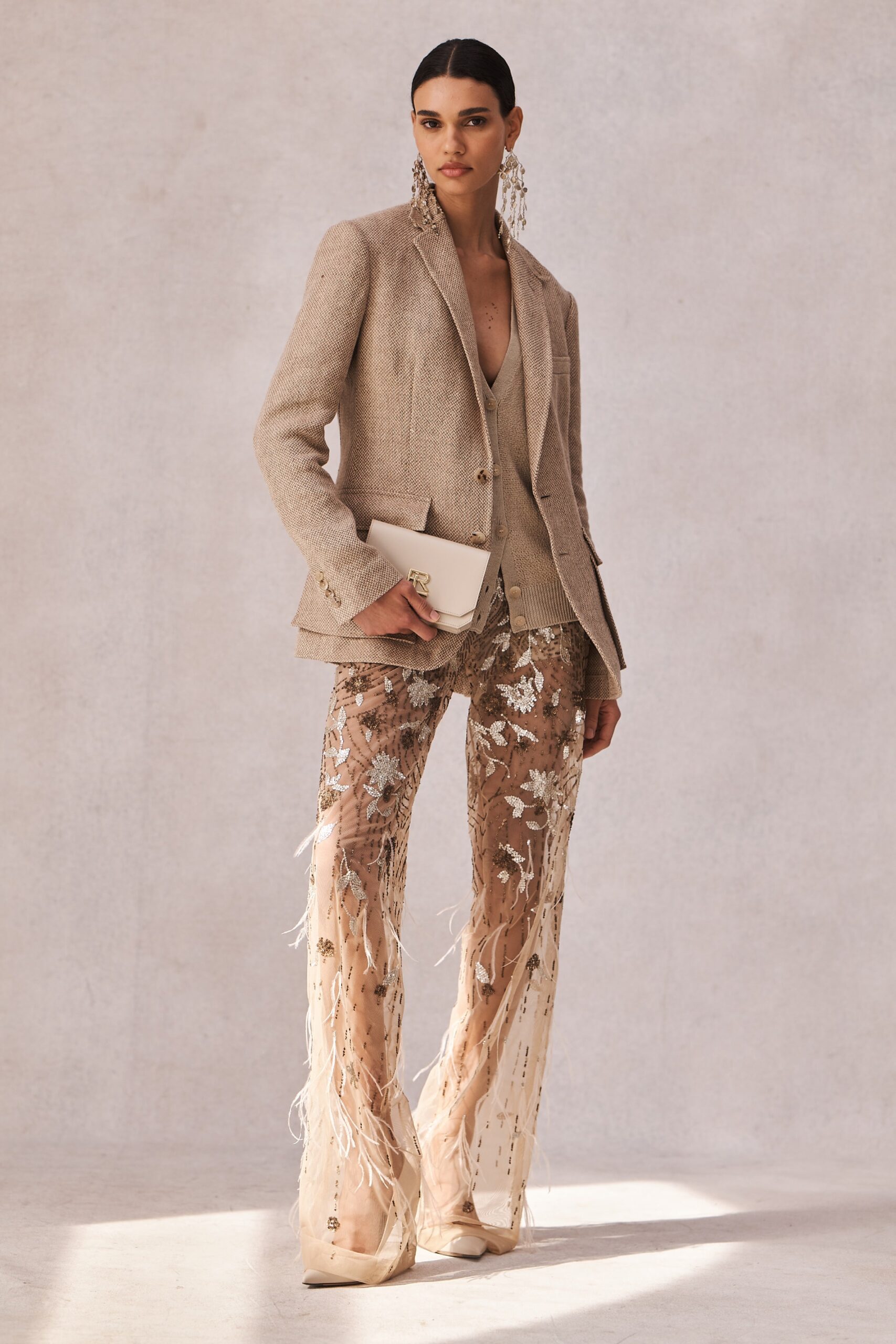 A fitted beige silk blazer paired with embroidered flared pants for a sophisticated look.