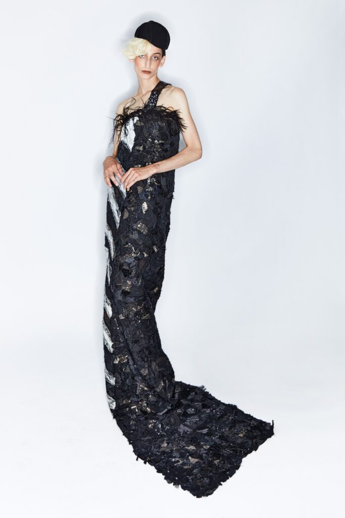 A fitted black silk dress with a sleeveless design and layered details.