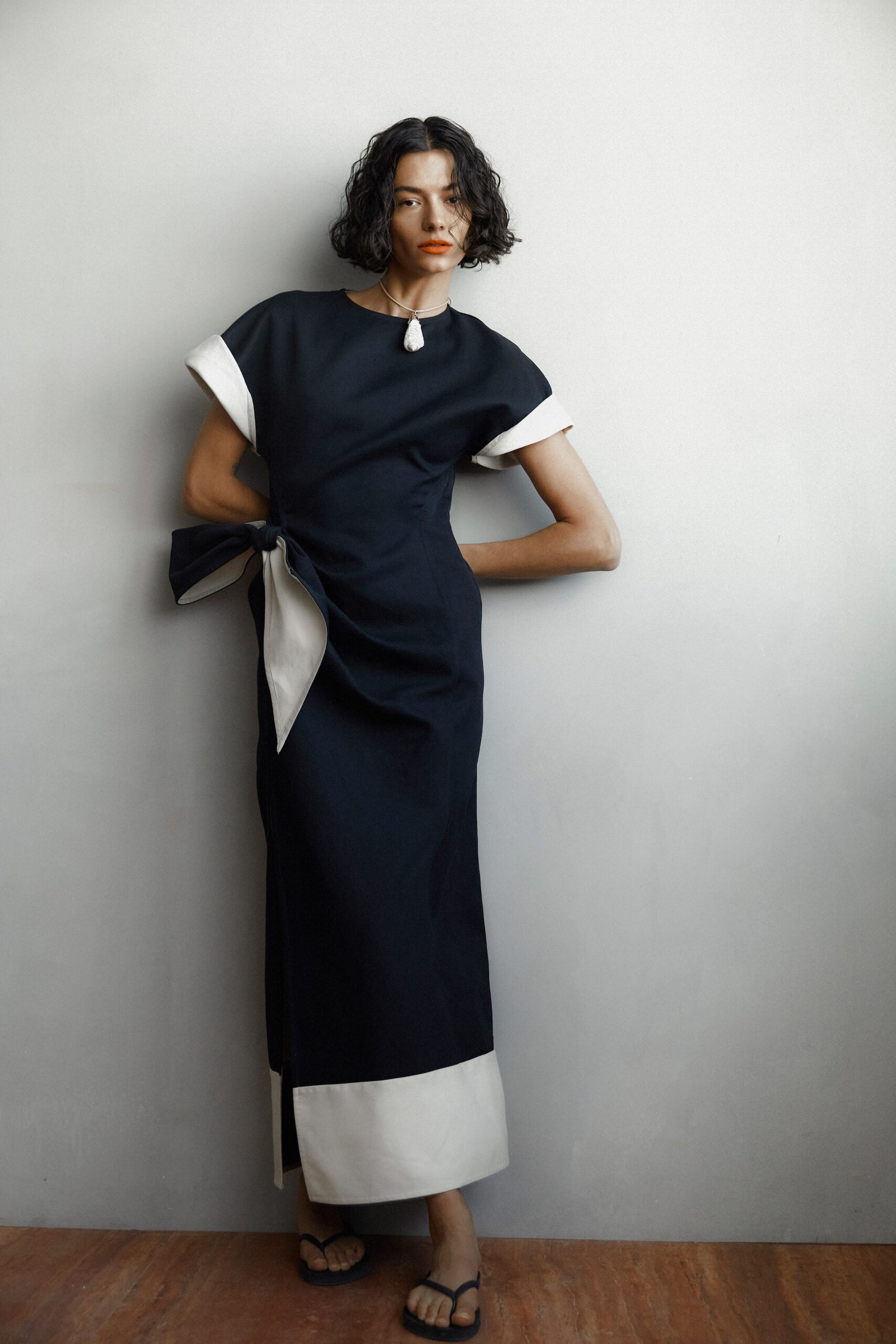 A fitted black and white dress with short sleeves and an asymmetric design detail.