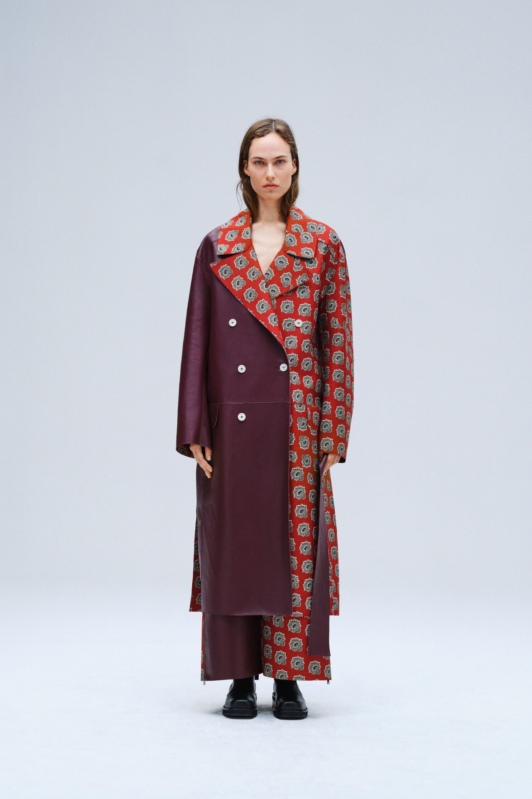A relaxed burgundy leather coat with long sleeves, a collared neckline, and an asymmetric design.