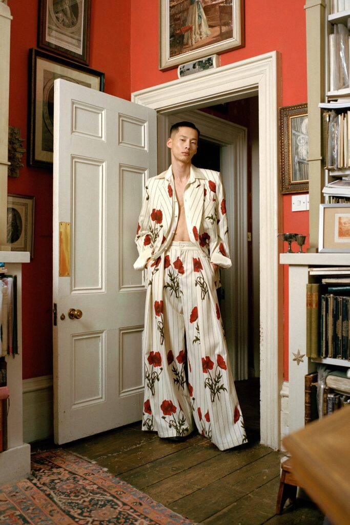 A relaxed white suit with red floral patterns and stripes, featuring long sleeves and a collared design.