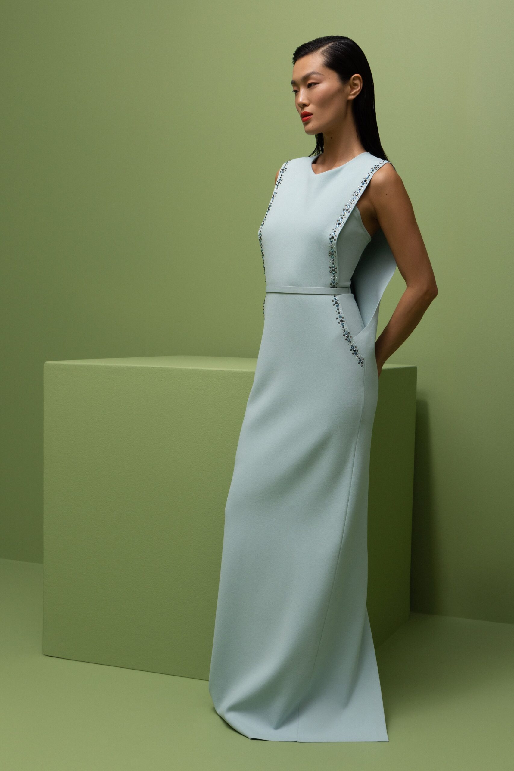 A fitted blue silk dress with a high neckline and straight-leg silhouette.