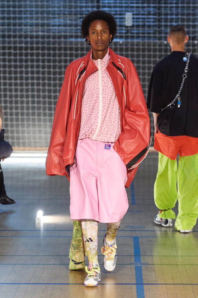 An oversized red leather jacket paired with a printed pink top, showcasing a layered look.