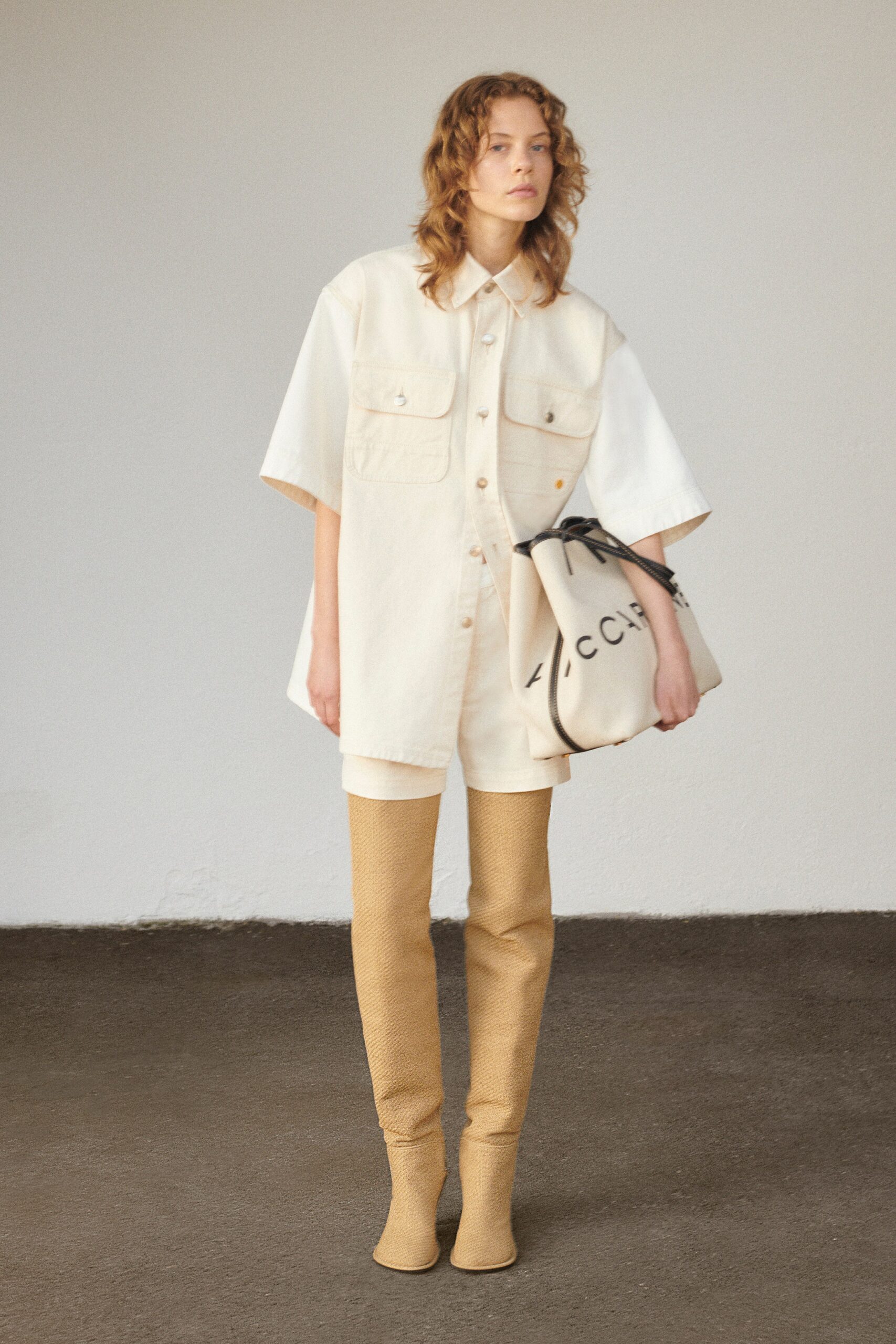 A relaxed beige cotton shirt with short sleeves and matching shorts, featuring a collared design.