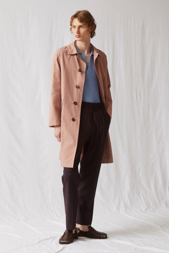 A relaxed pink cotton coat paired with straight-leg black pants and a collared long-sleeve shirt.