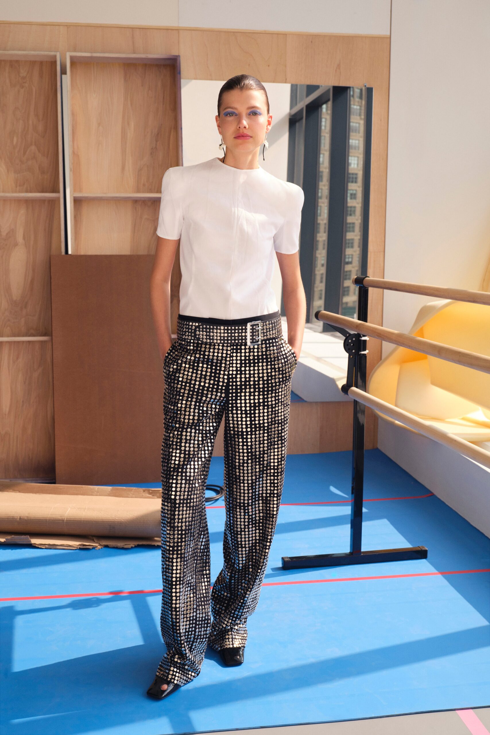 A fitted white shirt with short sleeves paired with wide-leg printed pants.