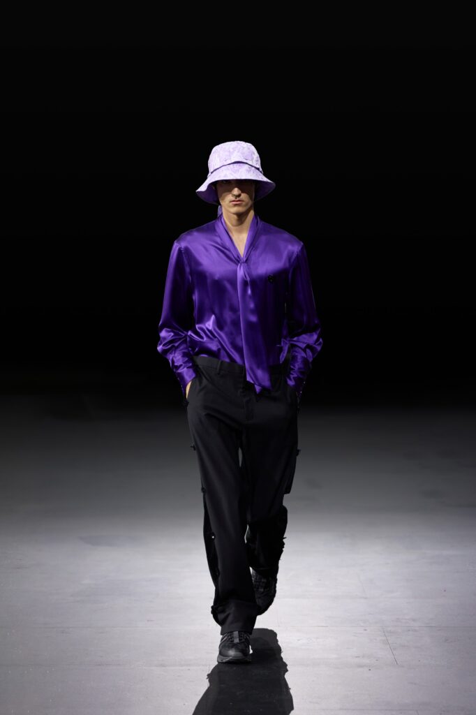 A purple silk long-sleeve shirt paired with black pants, creating a stylish ensemble.