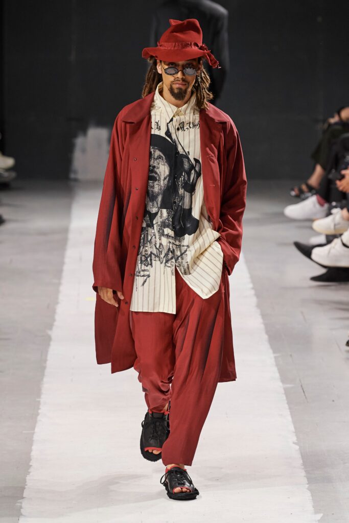 A relaxed red coat paired with printed pants, featuring a long-sleeve collared design.